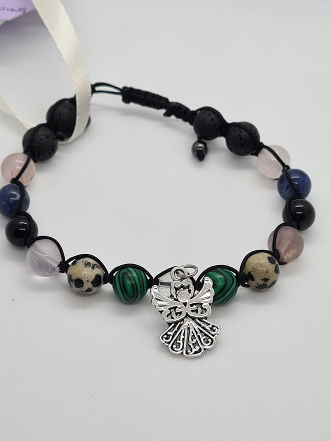 A beaded bracelet featuring black lava stone beads, green malachite beads, Lapis Lazuli, Ametrine and Rose Quartz crystal beads, a silver angel charm, and a black adjustable cord closure 