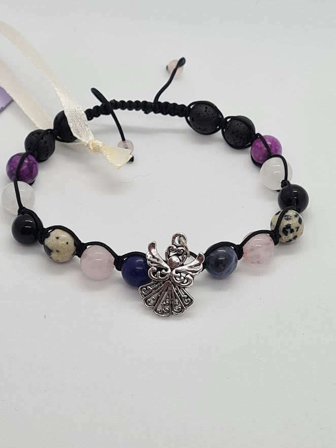A beaded bracelet featuring black lava stones, purple amethyst, rose quartz, dark blue lapis lazuli, and dalmatian jasper beads, accented by a silver-toned angel charm.